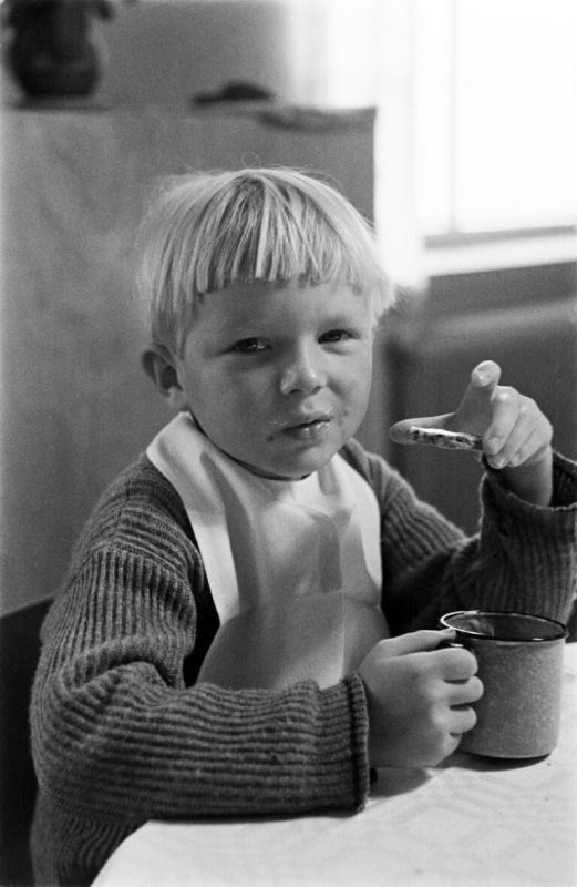 Mustavalkokuva lapsesta syömässä näkkileipää.