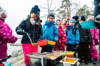 Children queuing for lunch outside.